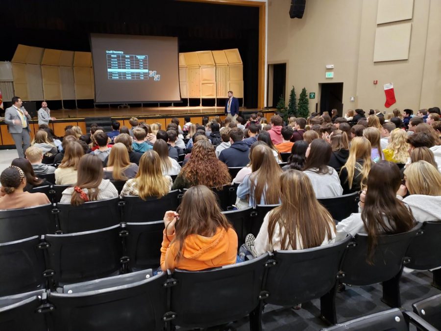 Students listen attentively in the auditorium to updates provided by administration.